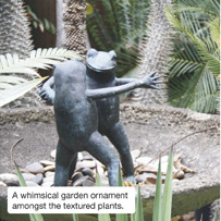 A whimsical garden ornament amongst the textured plants.